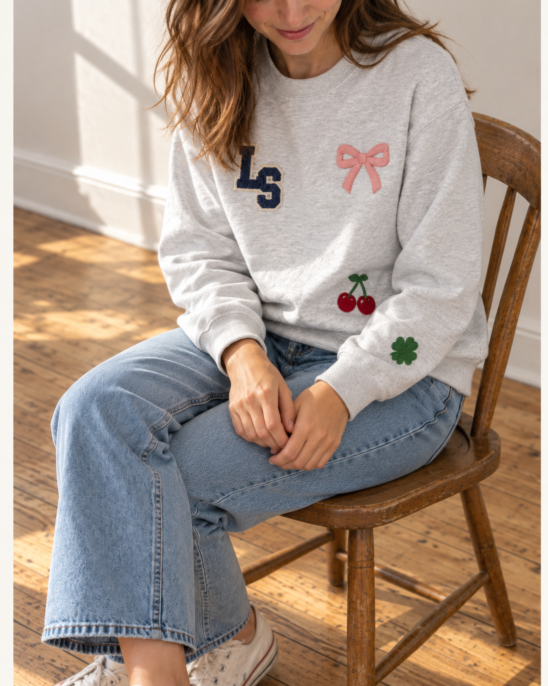 Woman wearing a personalized patch crewneck sweatshirt, an employee appreciation gift