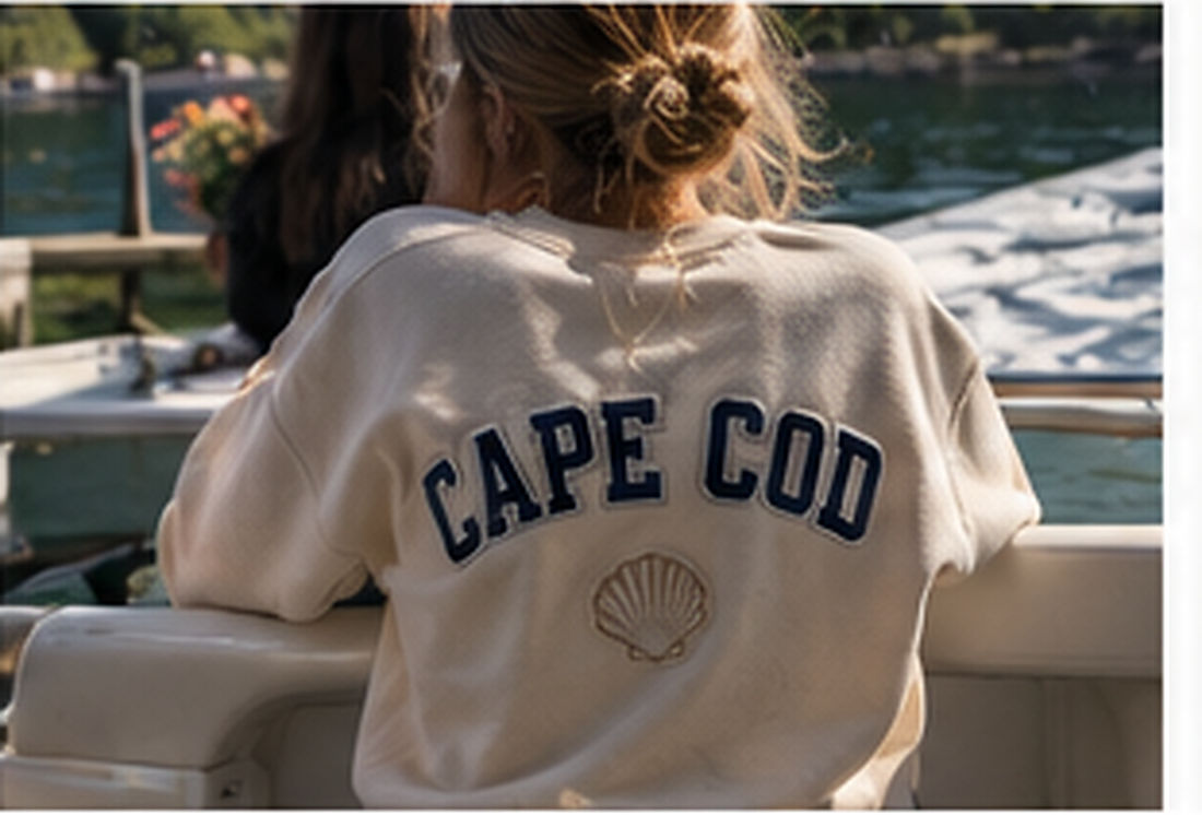 Woman on a boat wearing a cream Cape Cod patched crewneck sweatshirt