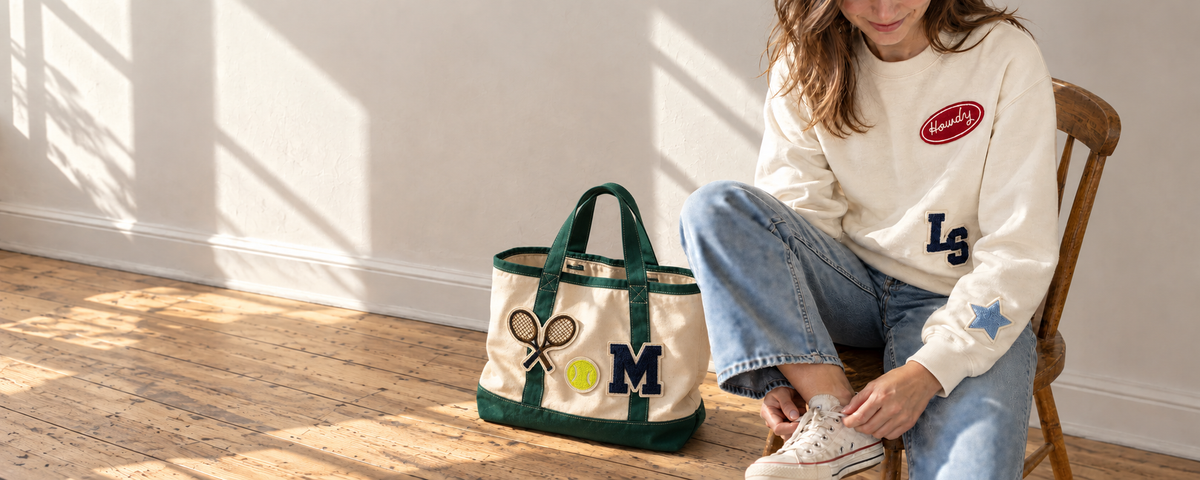 Green patch tote next to a cream patch crewneck